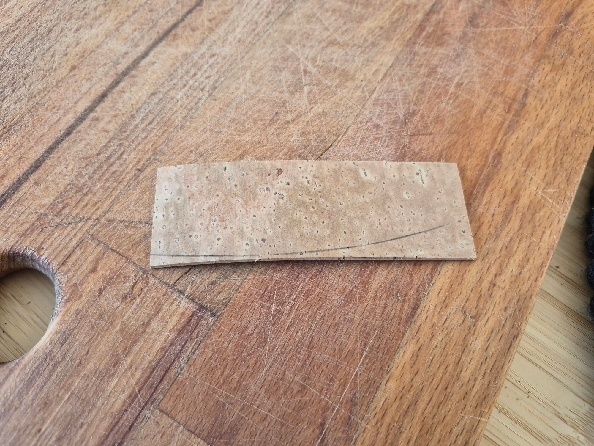 The cork slice showing the arc along which to cut.